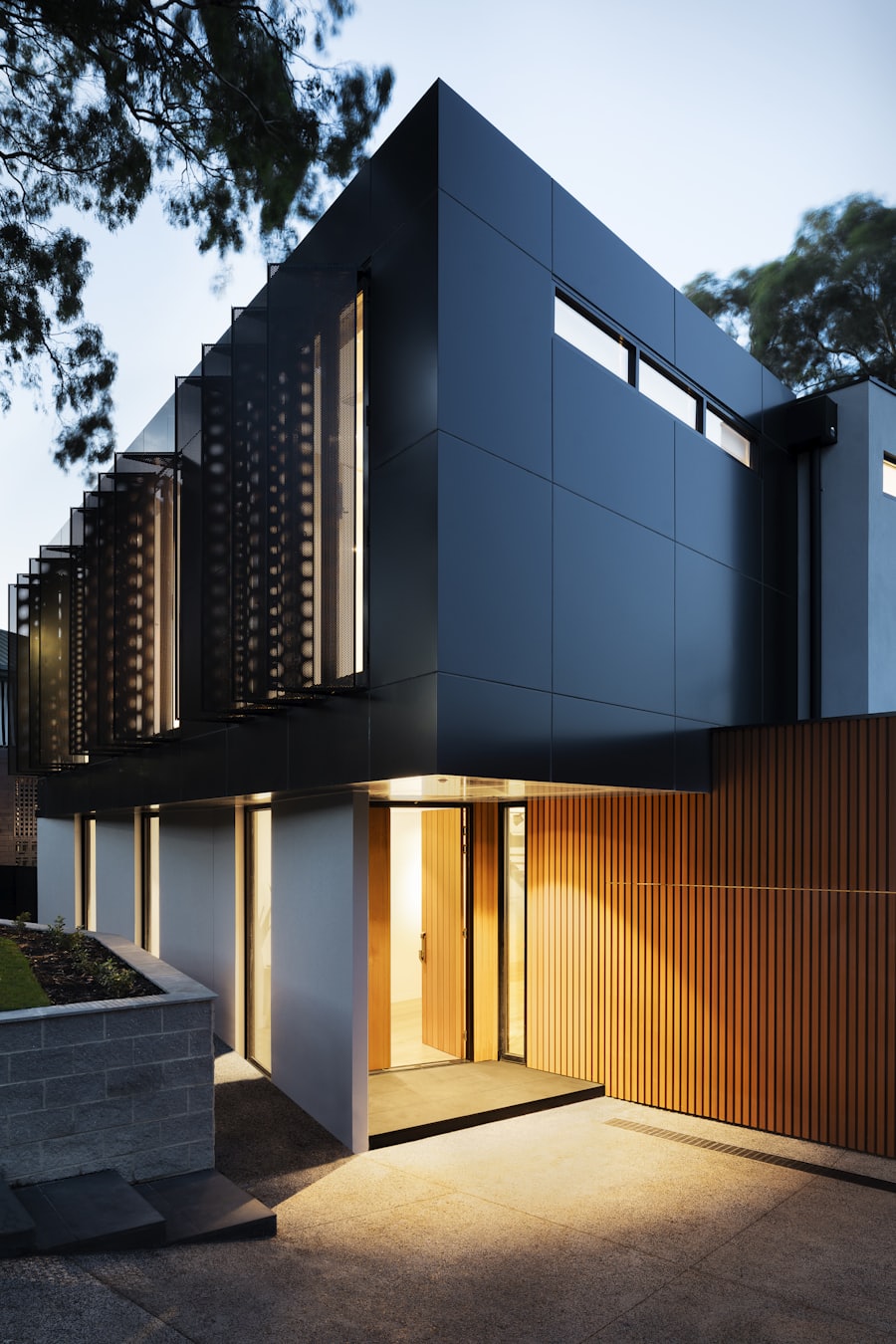 Contemporary luxury home with cantilevered roof, dark cladding, and stone accents under mountain skies.